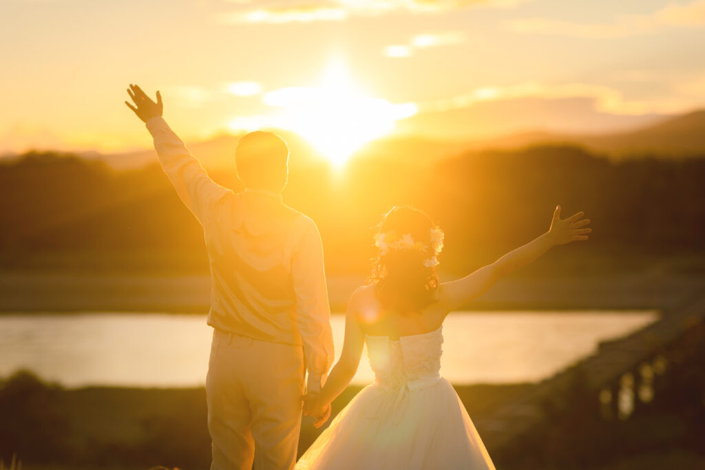 フォトウェディング　夕日　洋装の新郎新婦