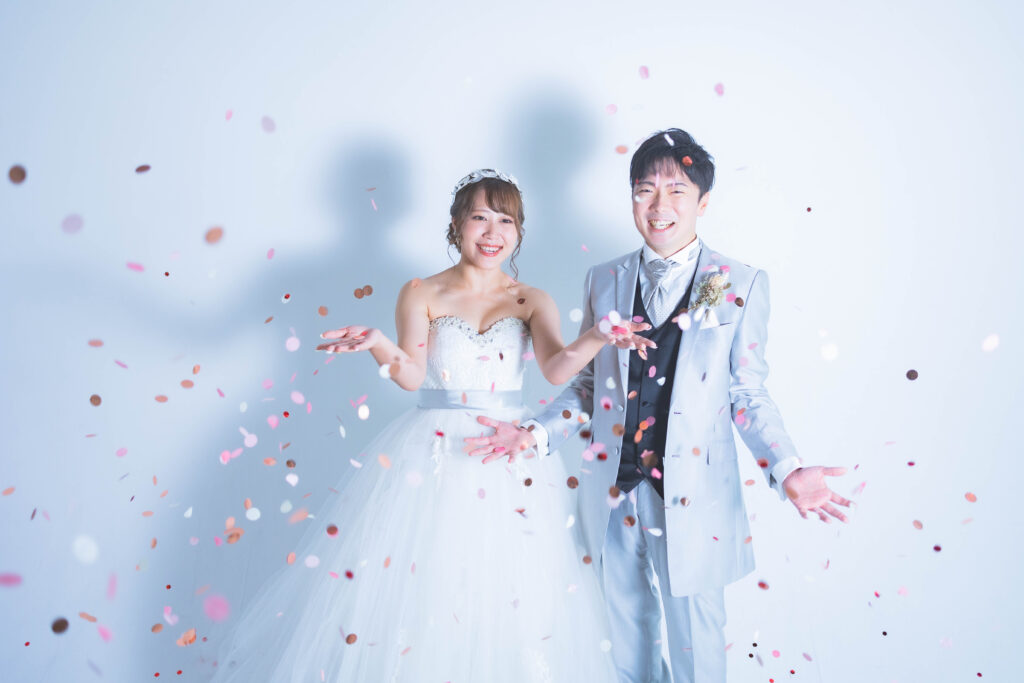 コンフェッティーシャワーをする新郎新婦