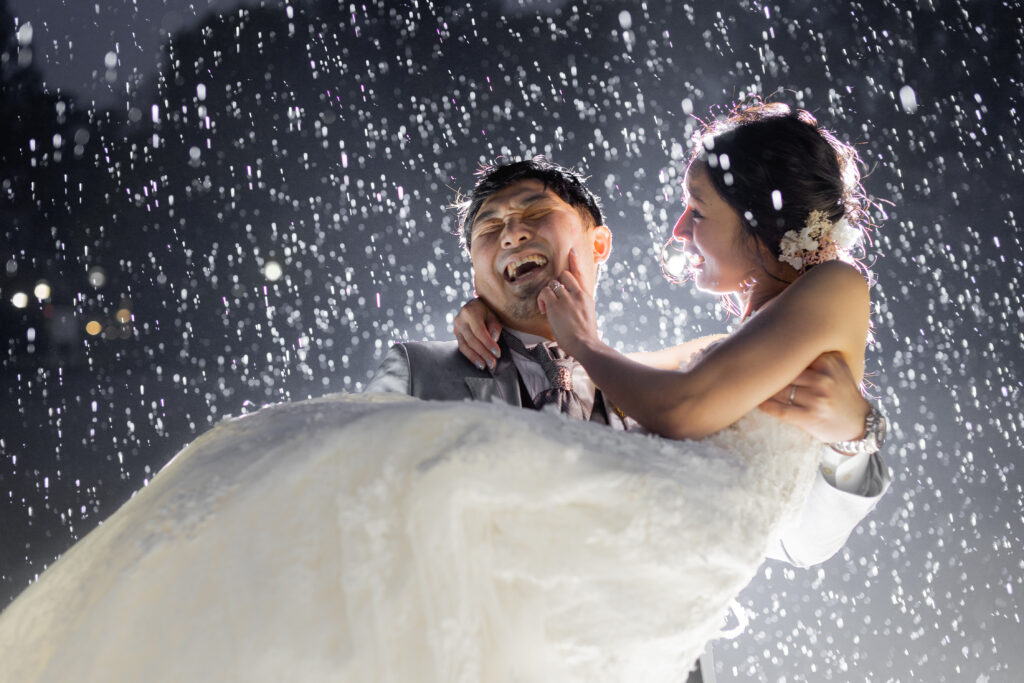 雨の中ウェディング撮影楽しむ新郎新婦