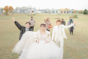 ウェディングフォトでスタッフと家族と一緒に写真を撮る新郎新婦